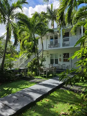 a white house with palm trees and a patio at West Ave in Miami Beach