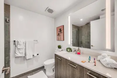a bathroom with a sink and a toilet and a mirror at Sublime Views Studio in Miami