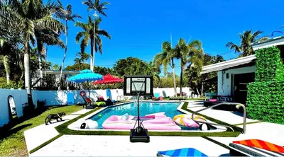 a swimming pool with a basketball hoop in a yard at Delano in Fort Lauderdale