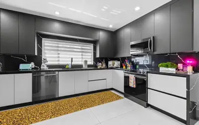 a kitchen with black cabinets and white counter tops at Delano in Fort Lauderdale
