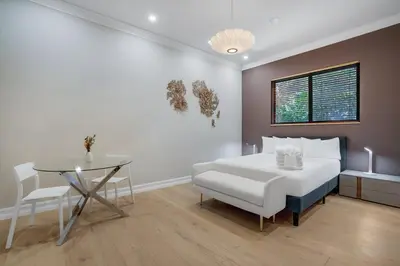 a bedroom with a white bed and a glass table at WATERFRONT MANSION Las Olas in Fort Lauderdale