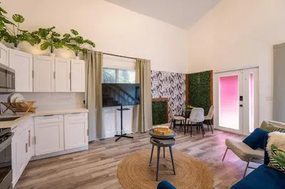 a kitchen and living room with white cabinets and a table at Mar & Luna Family retreat in Miami