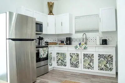 a kitchen with white cabinets and a stainless steel refrigerator at Mar & Luna Family retreat in Miami