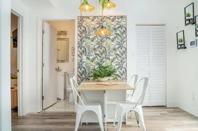 a dining room with a table and white chairs at Mar & Luna Family retreat in Miami