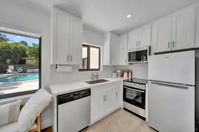 a kitchen with white cabinets and a pool at Waterfront Unit #1 20 Min Walk to Beach and Shops in Fort Lauderdale