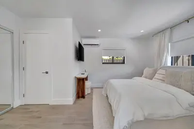 a white bedroom with a bed and a window at Waterfront Unit #1 20 Min Walk to Beach and Shops in Fort Lauderdale