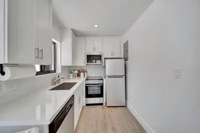 a white kitchen with white appliances and white cabinets at Waterfront Unit #1 20 Min Walk to Beach and Shops in Fort Lauderdale