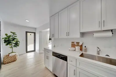 a white kitchen with a sink and a dishwasher at Waterfront Unit #2 20 Min Walk to Beach and Shops in Fort Lauderdale