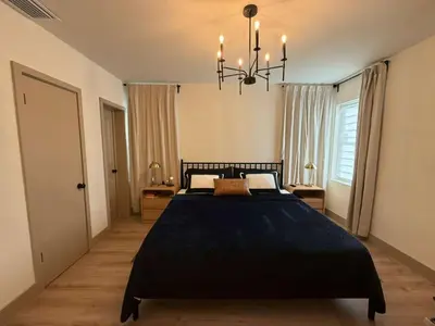 a bedroom with a large black bed and a chandelier at Trio in Miami
