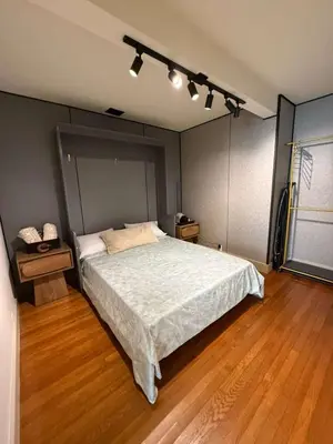 a bedroom with a large bed and wooden floors at Trio in Miami