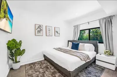a white bedroom with a bed and a window at Sunny Miami Escape in Prime Location