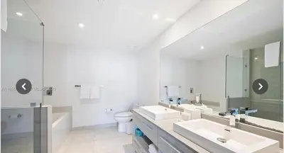 a white bathroom with two sinks and a toilet at Hyde house 3507 AL MAR in Hollywood