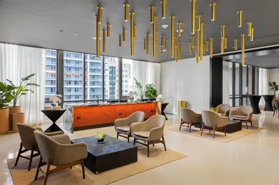 a lobby with chairs and a table and a chandelier at 2907 Modern Apartment in Downtown Miami with Pool and Gym in Miami