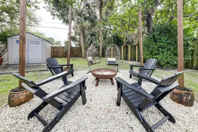 a group of chairs and a table in a yard at 5 Mi to Las Olas Beach! Bright Home with Fenced Yard in Fort Lauderdale