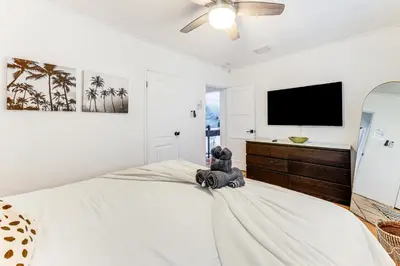 a teddy bear sitting on a bed in a bedroom at 5 Mi to Las Olas Beach! Bright Home with Fenced Yard in Fort Lauderdale
