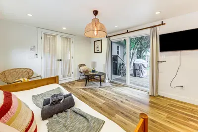 a living room with a bed and a sliding glass door at 5 Mi to Las Olas Beach! Bright Home with Fenced Yard in Fort Lauderdale