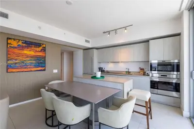 a kitchen with a table and chairs in a room at Oceanfront dream W pool & beach access in Hollywood