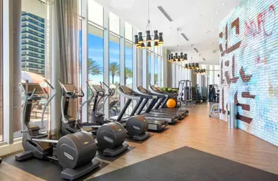a gym with a row of treadmills and ellipticals at Oceanfront dream W pool & beach access in Hollywood