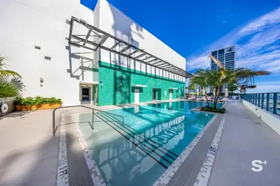 a swimming pool in front of a building at Cozy Ensuite 1BR Apartment in DTW Miami in Miami