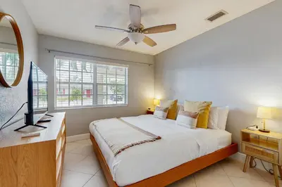 a bedroom with a bed and a ceiling fan at The Palms in Fort Lauderdale