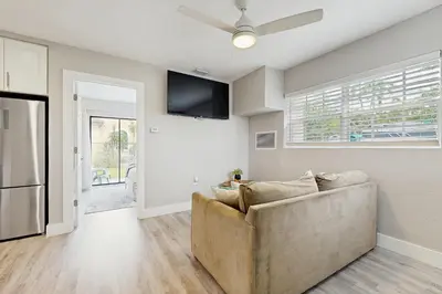 a living room with a couch and a ceiling fan at The Palms A in Fort Lauderdale
