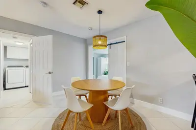 a dining room with a wooden table and white chairs at The Palms B in Fort Lauderdale