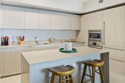 a kitchen with a counter with two stools and a sink at Lux Beachfront Retreat at Hyde Resort w OceanView in Hollywood