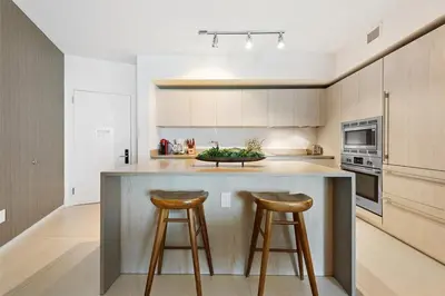 a kitchen with a large island with two bar stools at Lux Beachfront Retreat at Hyde Resort w OceanView in Hollywood