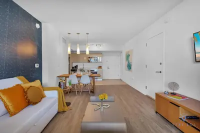a living room with a couch and a dining room at Spectacular Near Beach 2 BR Apartment in Hallandale Beach