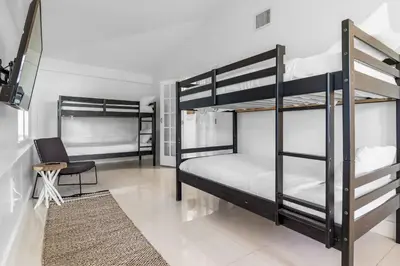 a bedroom with two bunk beds and a chair at 7BD Downtown Oasis - Pool - 10 Mins to South Beach in Miami