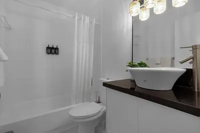 a white bathroom with a sink and a toilet at 7BD Downtown Oasis - Pool - 10 Mins to South Beach in Miami