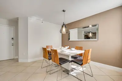 a dining room with a white table and chairs at Resort Condo By Aventura Mall! Gated Community in Aventura