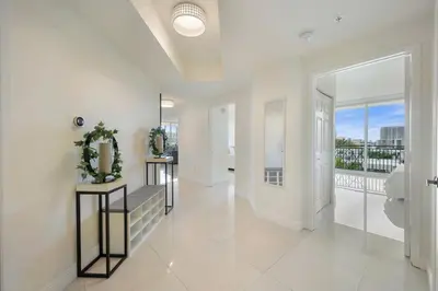 a large white hallway with a staircase and a balcony at Spacious 3BR Condo Across from Beach with Ocean & City Views in Sunny Isles Beach