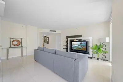 a living room with a couch and a tv at Spacious 3BR Condo Across from Beach with Ocean & City Views in Sunny Isles Beach