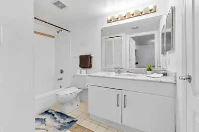 a white bathroom with a toilet and a sink at Upscale4 Brickell Retreat with Bay n City Views in Miami