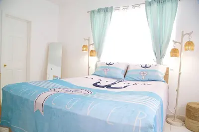 a bedroom with a blue and white bed with a window at Cozy3 Miami Beach Getaway Quick Walk to the Ocean in Miami Beach
