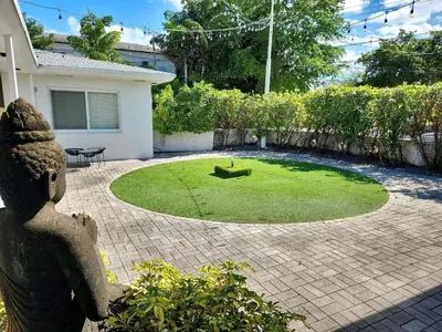 a garden with a small circle of grass in front of a house at Miami Studio a Few Steps to the Beach in Miami