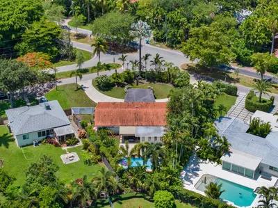 an aerial view of a house with a pool and trees at Spacious Miami Home with Private Pool & Parking in Biscayne Park