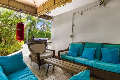 a patio with a couch and a bench and a table at Spacious Miami Home with Private Pool & Parking in Biscayne Park