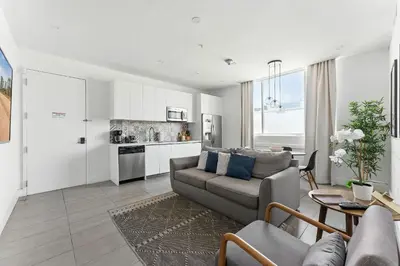 a living room with a couch and a kitchen at Apto 2 Quartos c/ Varanda South Beach Central in Miami Beach