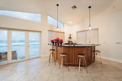 a kitchen with a counter with stools and a sink at Oceanfront Luxury Villa 5Bedroom and 4Bath Beach Access in Hollywood