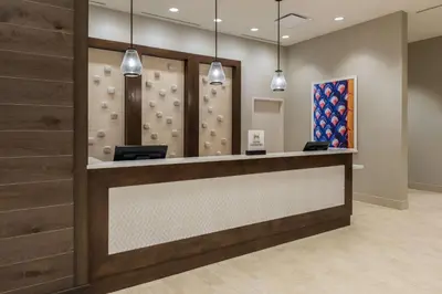 a lobby with a rock wall and a reception counter at Homewood Suites by Hilton Miami Dolphin Mall in Miami