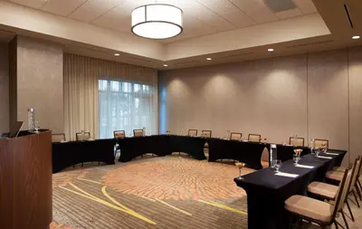 a conference room with tables and chairs and a podium at Homewood Suites by Hilton Miami Dolphin Mall in Miami