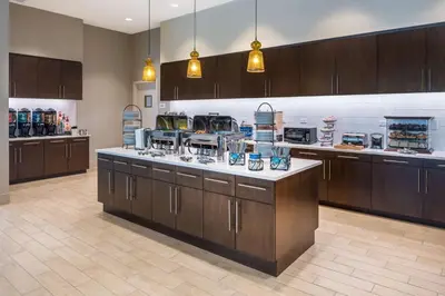 a large kitchen with wooden cabinets and a counter top at Homewood Suites by Hilton Miami Dolphin Mall in Miami