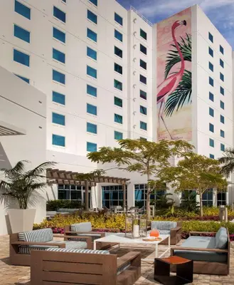 a hotel with tables and chairs in front of a building at Homewood Suites by Hilton Miami Dolphin Mall in Miami