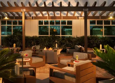 an outdoor patio with couches and tables and candles at Homewood Suites by Hilton Miami Dolphin Mall in Miami