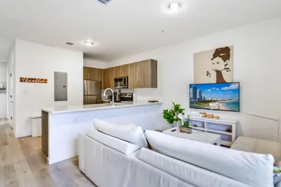 a living room with a white couch and a kitchen at Miami Townhouse Stay with Free Parking in Miami