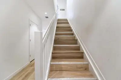 a staircase in a house with white walls and wooden floors at Miami Townhouse Stay with Free Parking in Miami