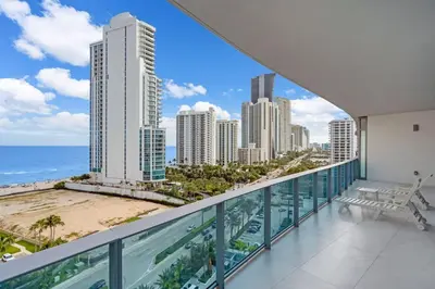 a balcony with a view of the beach and buildings at Chic OceanView 2 Bedroom with Free Parking Pool Jacuzzi in Sunny Isles Beach