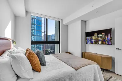 a bedroom with a bed and a large window at Corner Chic 2 Bedroom Downtown with Rooftop Pool & Views in Miami